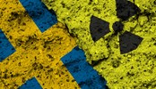 Concept of the Nuclear Energy Policy of Sweden with a flag and a radiation hazard sign painted on a rough wall.