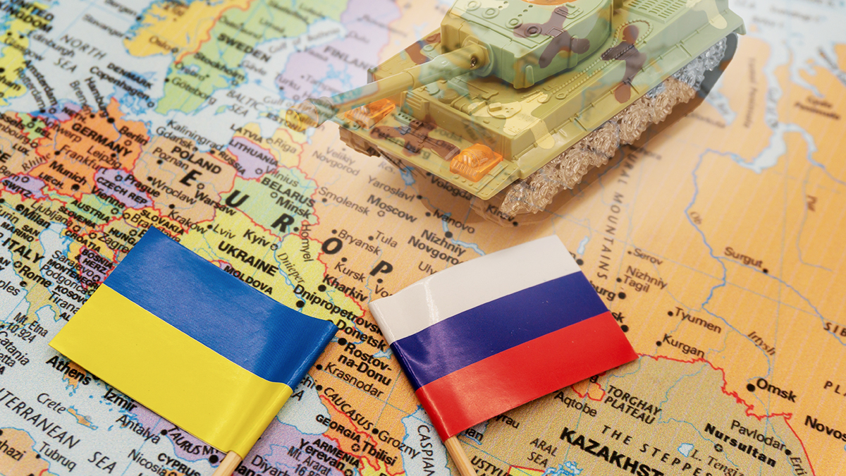 Ukrainian and Russian flags placed on a map of Europe.