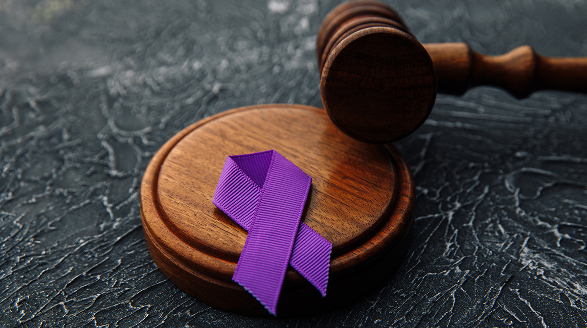 Violet ribbon and gavel on grey background - Concept of Domestic Violence law