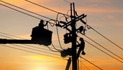 Silhouette of Electrician officer climbs a pole and uses a cable car to maintain a high voltage line system, Shadow of Electrician lineman repairman worker at climbing work on electric post power pole