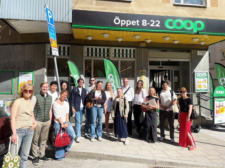 Group of students standing outside a COOP store in a sunny weather.